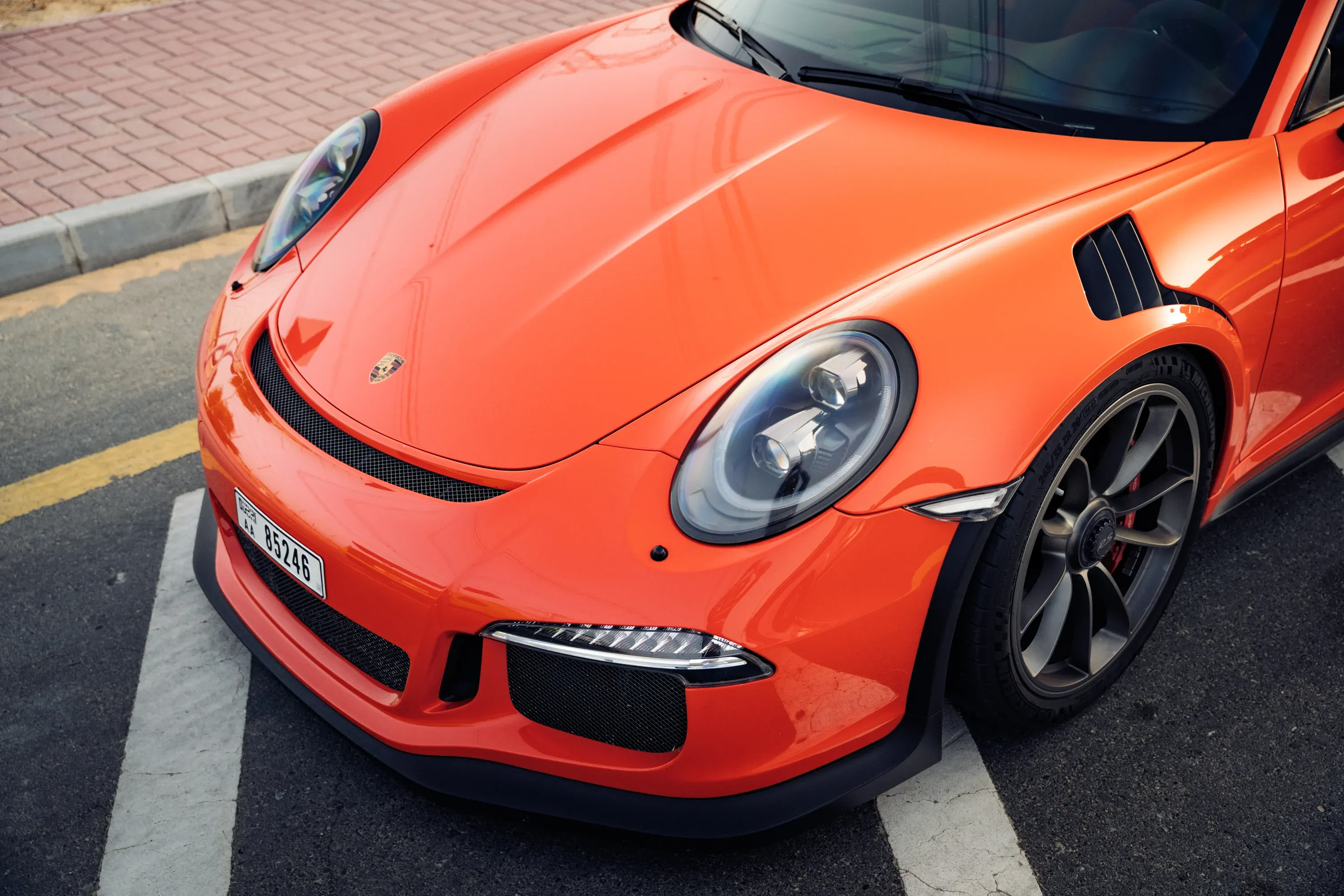 Rear view of Mercedes-Benz on a quiet road, lush foliage.