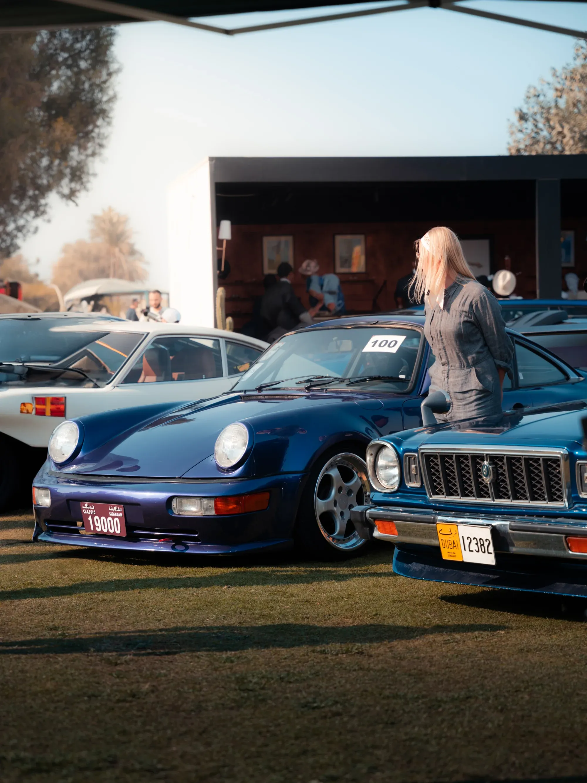 Classic Porsche in Martini Racing livery at an outdoor festival.
